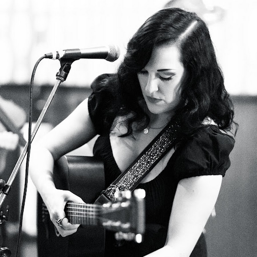 Kelsey Rae Copeland playing acoustic guitar in black and white